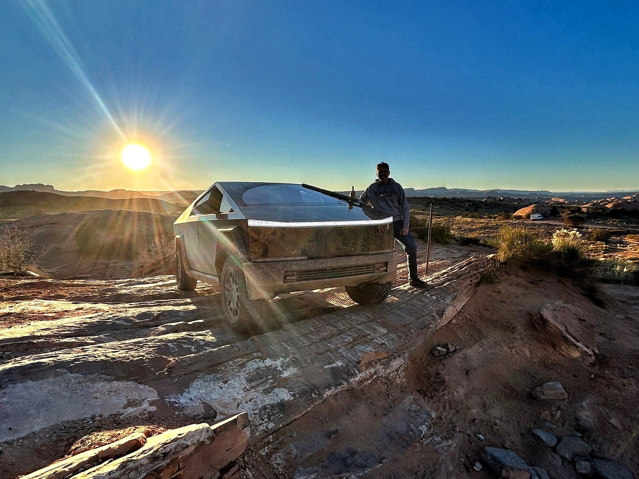 Person with Cybertruck at sunset giving thumbs up